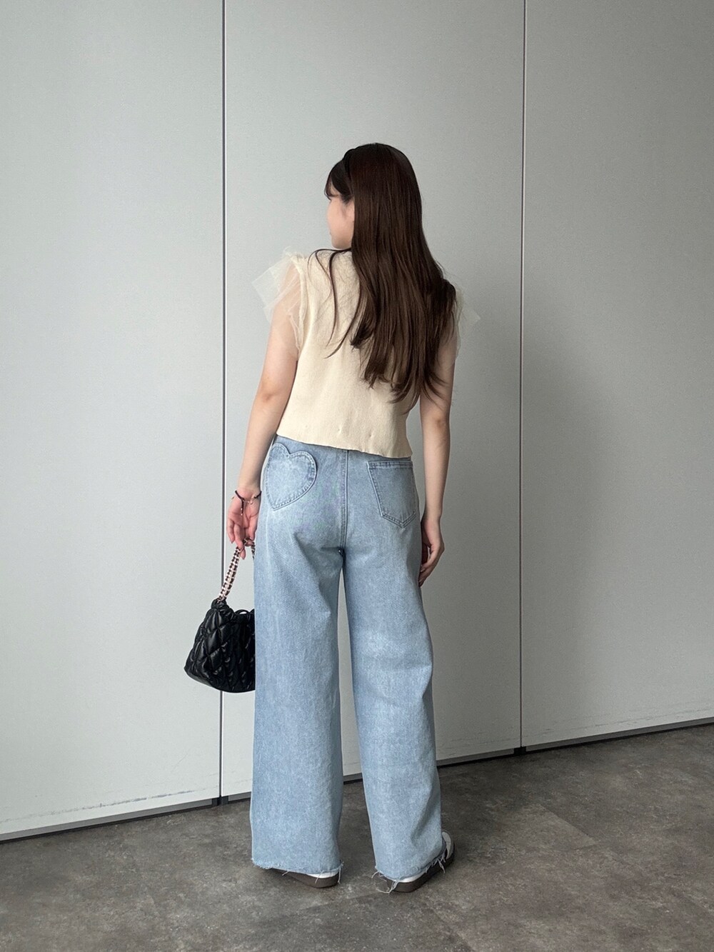 ブラック系のショルダーバッグ、ブルー系のデニムパンツ、ベージュ系のカーディガン/ボレロを着用したレディースの夏コーディネートの3枚目の写真