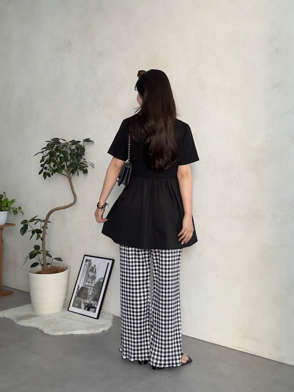 ブラック系のトートバッグ、ブラック系のサンダル、ブラック系のTシャツ/カットソーを着用したレディースの夏コーディネートの3枚目の写真