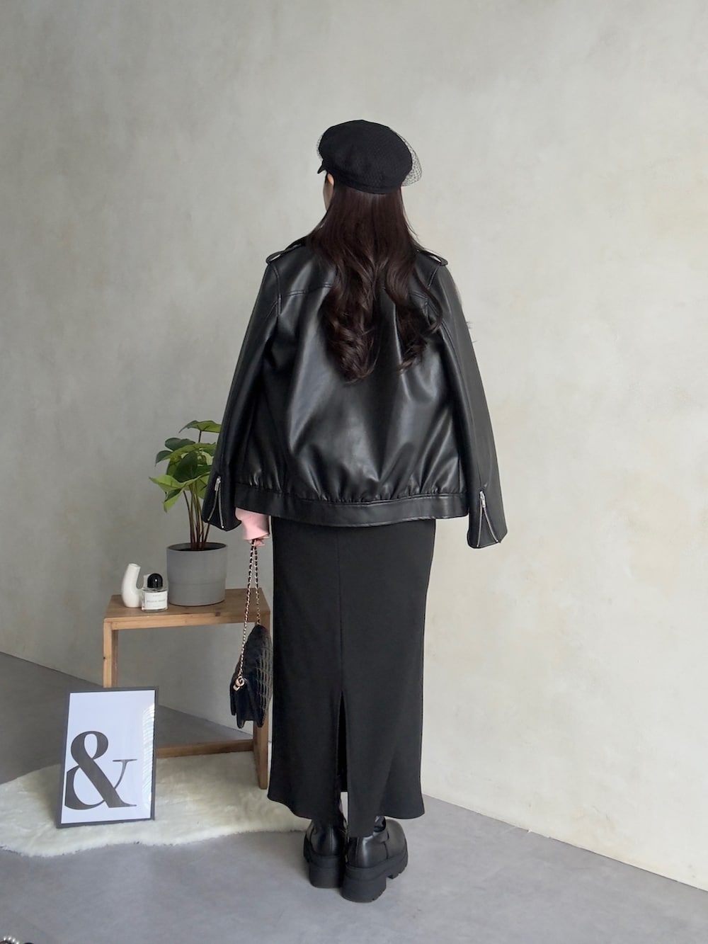 ブラック系のライダースジャケット、ブラック系のスカート、ブラック系のブーツを着用したレディースの冬コーディネートの3枚目の写真