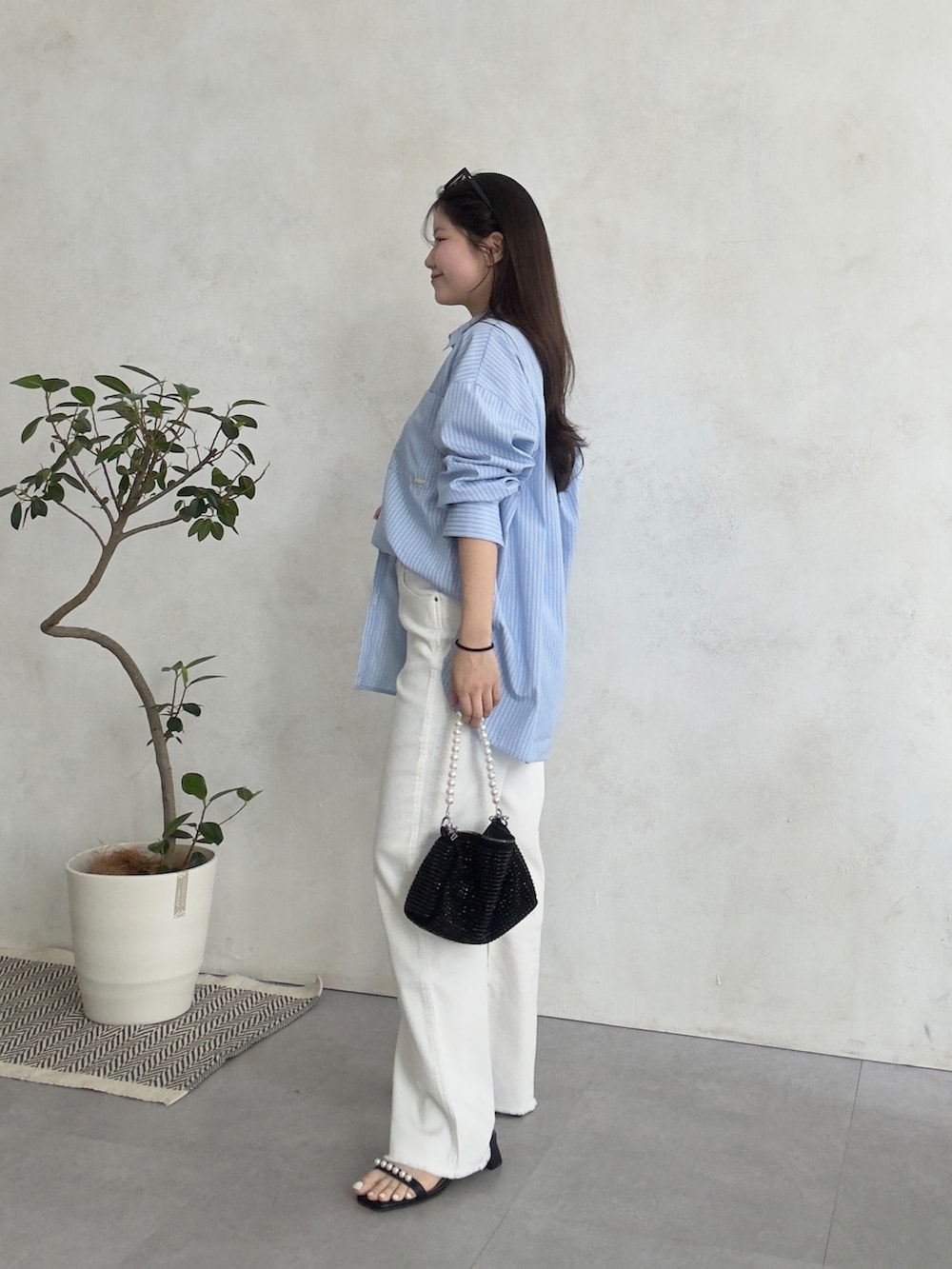 ホワイト系のその他パンツ、ブラック系のサンダル、ブルー系のシャツ/ブラウスを着用したレディースの春コーディネートの2枚目の写真