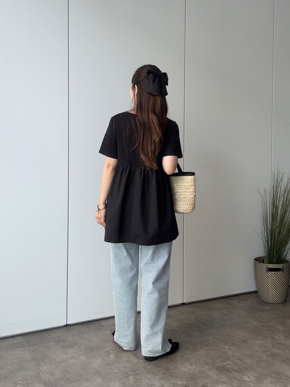 ブラック系のTシャツ/カットソー、ブルー系のデニムパンツ、ブラック系のかごバッグを着用したレディースの夏コーディネートの3枚目の写真