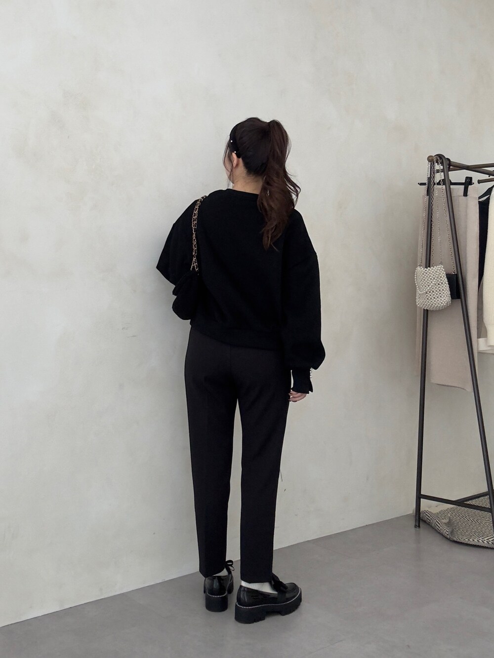 ブラック系のショルダーバッグ、ブラック系のその他パンツ、ブラック系のローファーを着用したレディースの秋コーディネートの3枚目の写真