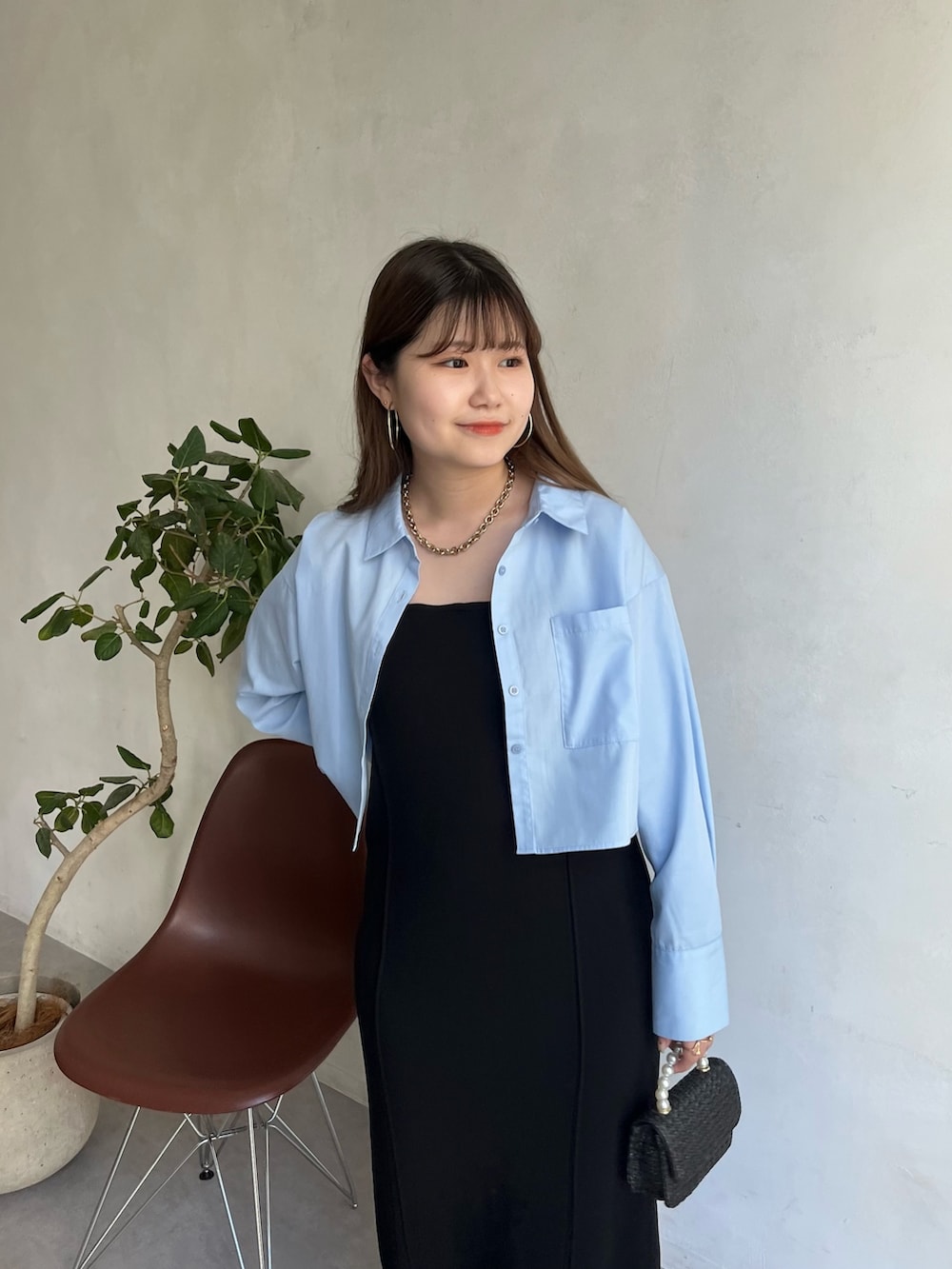 ブルー系のシャツ/ブラウス、ブラック系のワンピース、ブラック系のサンダルを着用したレディースの春コーディネートの2枚目の写真