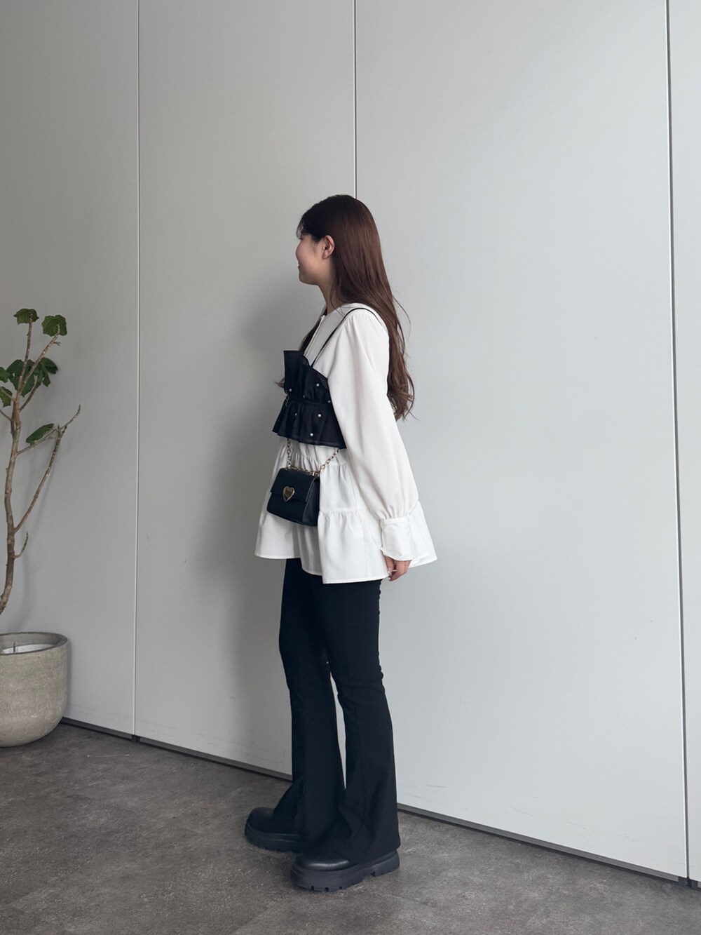 ブラック系のショルダーバッグ、ブラック系のその他パンツ、ホワイト系のシャツ/ブラウスを着用したレディースの冬コーディネートの2枚目の写真