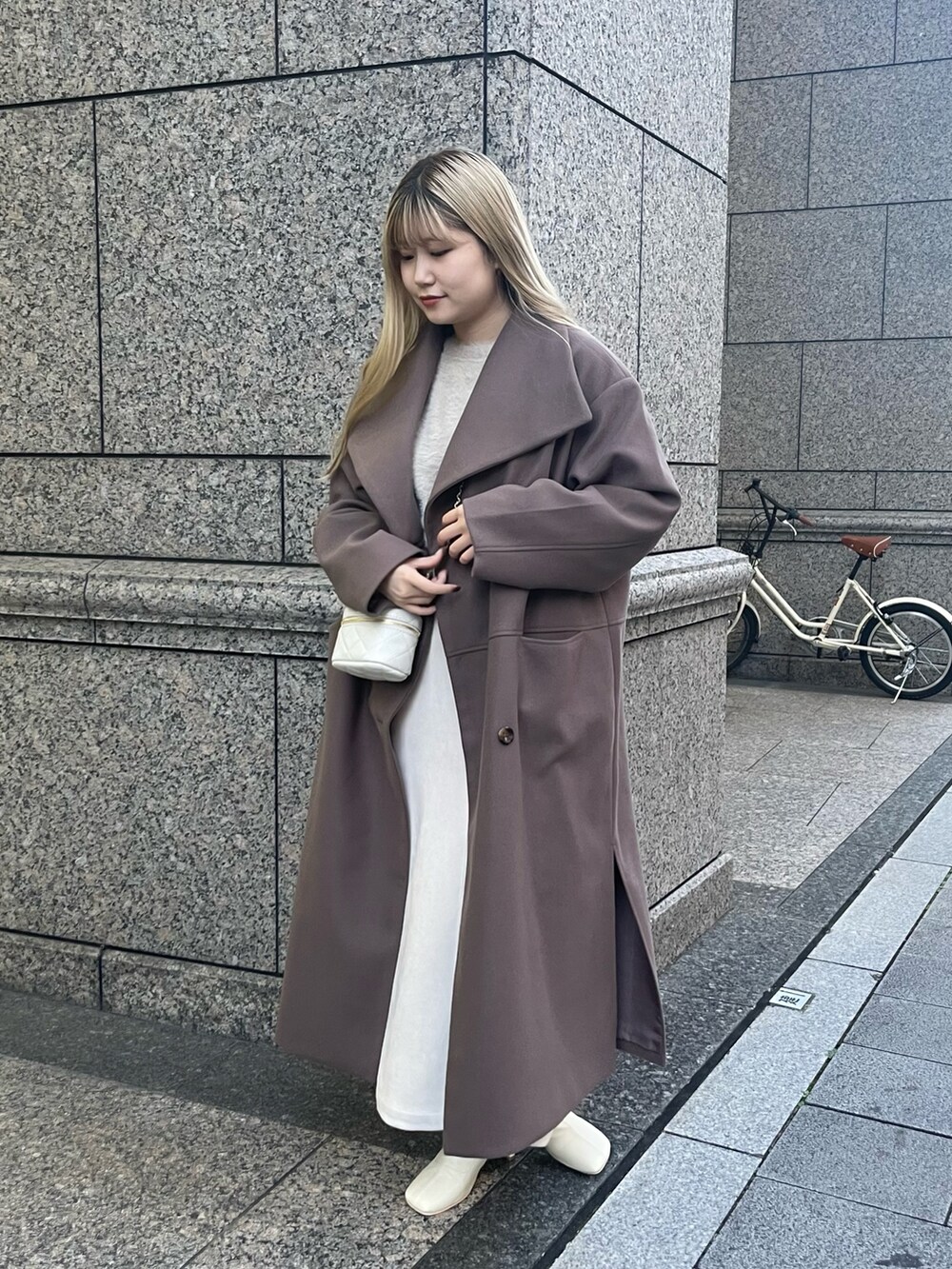 ベージュ系のカーディガン/ボレロ、ブラウン系のその他アウター、ホワイト系のスカートを着用したレディースの秋コーディネートの4枚目の写真