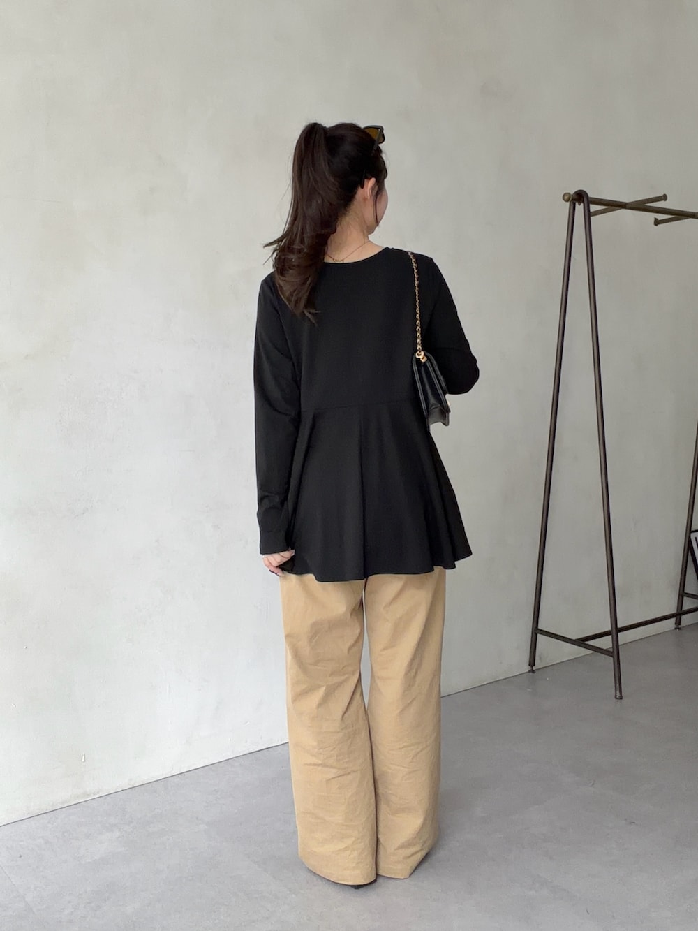 ベージュ系のチノパンツ、ブラック系のサンダル、ブラック系のTシャツ/カットソーを着用したレディースの春コーディネートの3枚目の写真