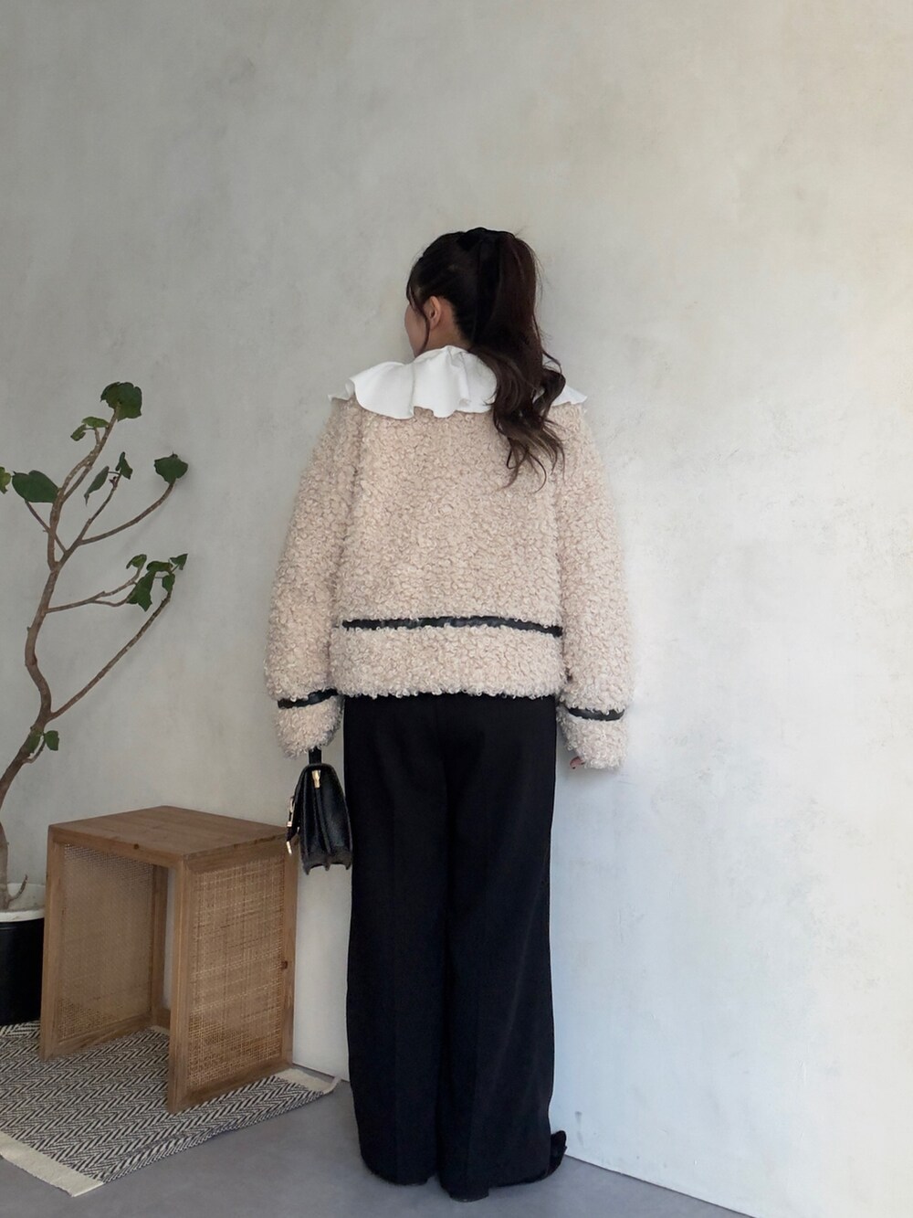 ホワイト系のスウェット、ホワイト系のブルゾン、ブラック系のスラックスを着用したレディースの秋コーディネートの3枚目の写真