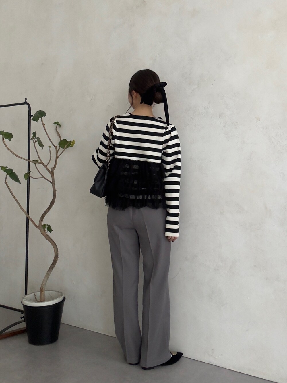 ブラック系のニット/セーター、グレー系のその他パンツを着用したレディースの秋コーディネートの3枚目の写真