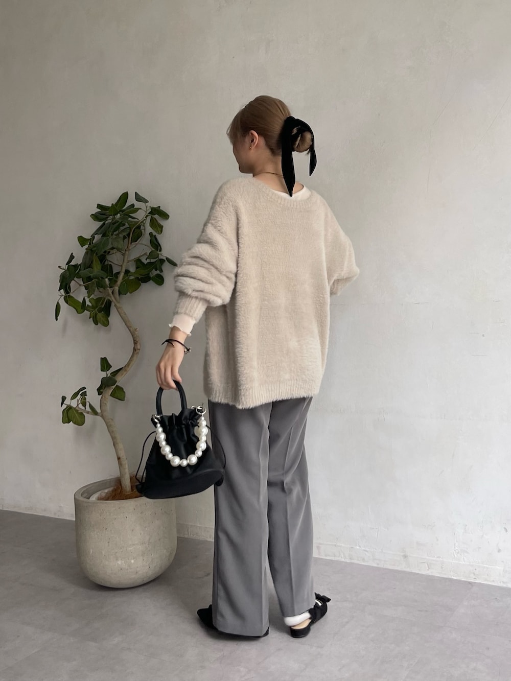 グレー系のスラックス、ブラック系のショルダーバッグ、ブラック系のパンプスを着用したレディースの夏コーディネートの2枚目の写真