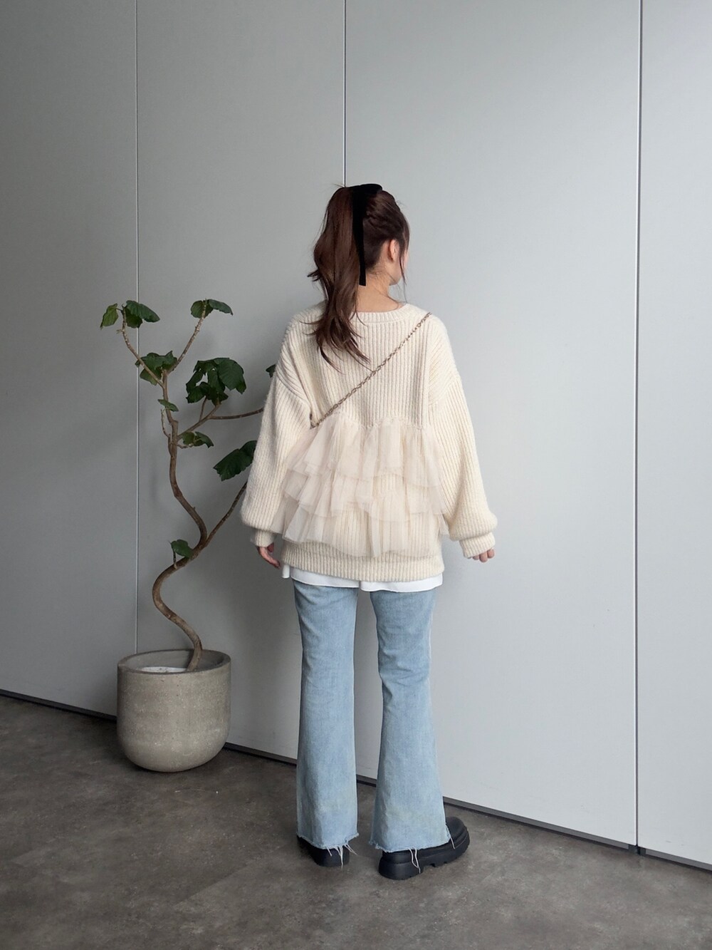 ベージュ系のカーディガン/ボレロ、ブラック系のブーツ、ブルー系のデニムパンツを着用したレディースの冬コーディネートの3枚目の写真