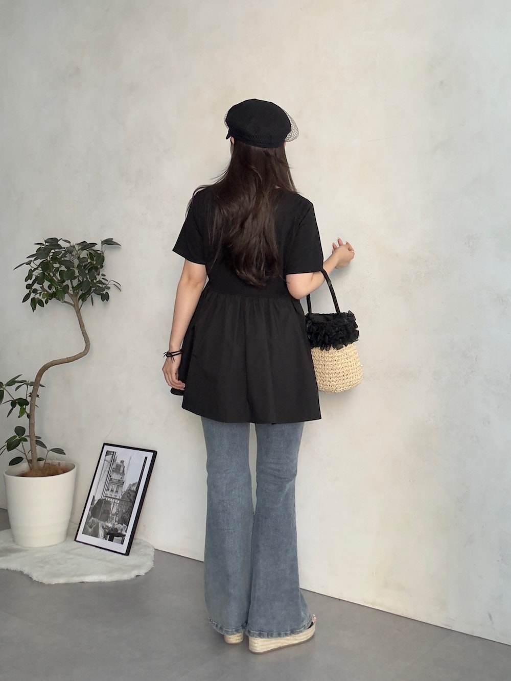 ベージュ系のかごバッグ、ブルー系のデニムパンツ、ブラック系のサンダルを着用したレディースの夏コーディネートの3枚目の写真