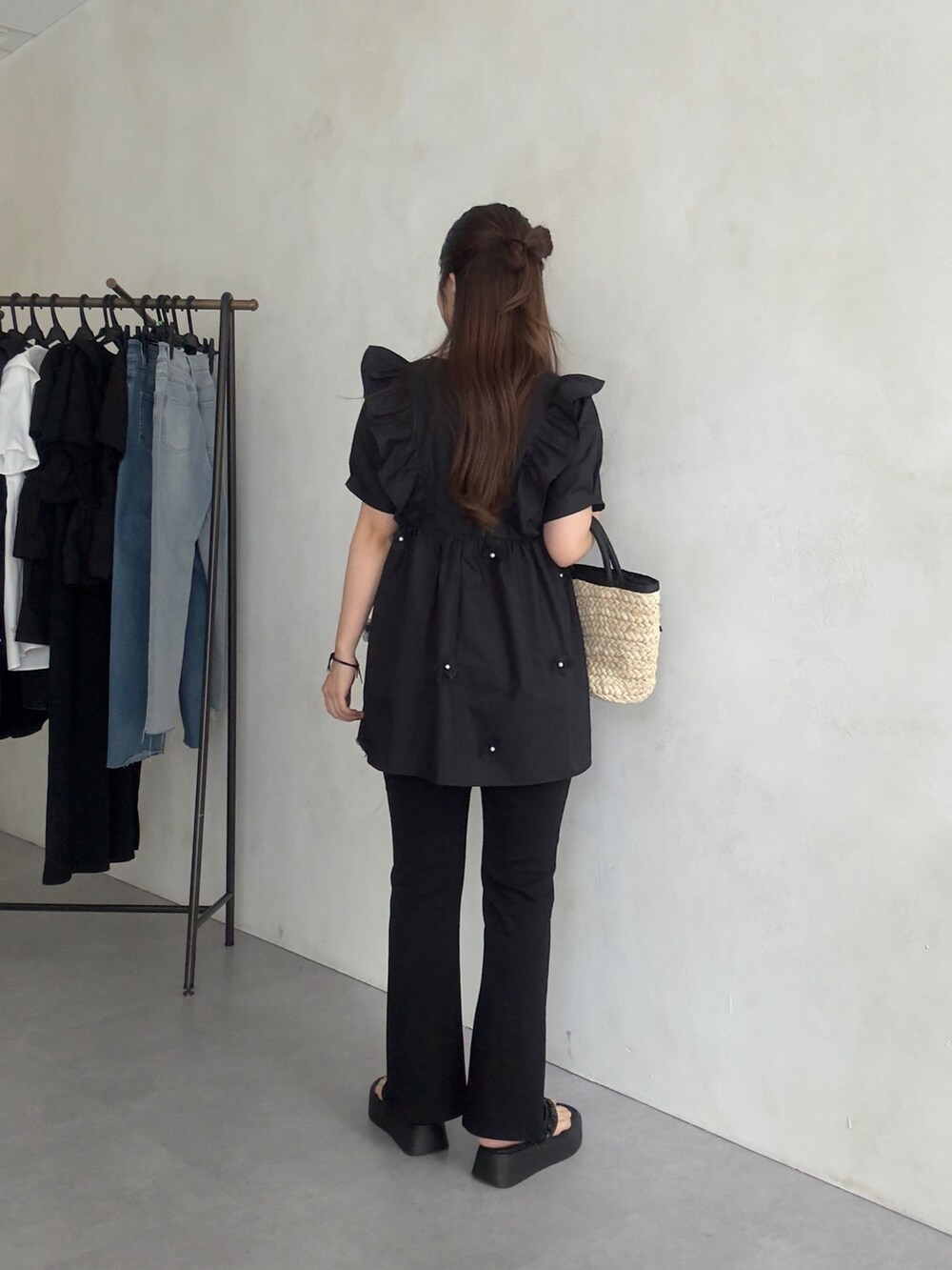 ブラック系のかごバッグ、ブラック系のサンダル、ブラック系のシャツ/ブラウスを着用したレディースの夏コーディネートの3枚目の写真