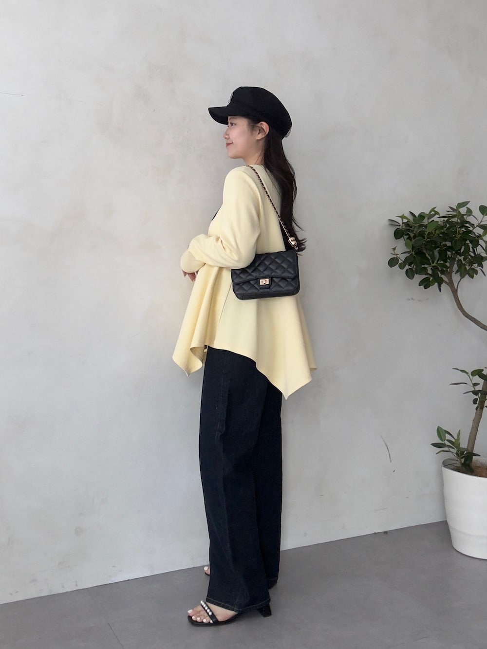 ブラック系のトートバッグ、ブラック系のサンダル、イエロー系のTシャツ/カットソーを着用したレディースの春コーディネートの2枚目の写真