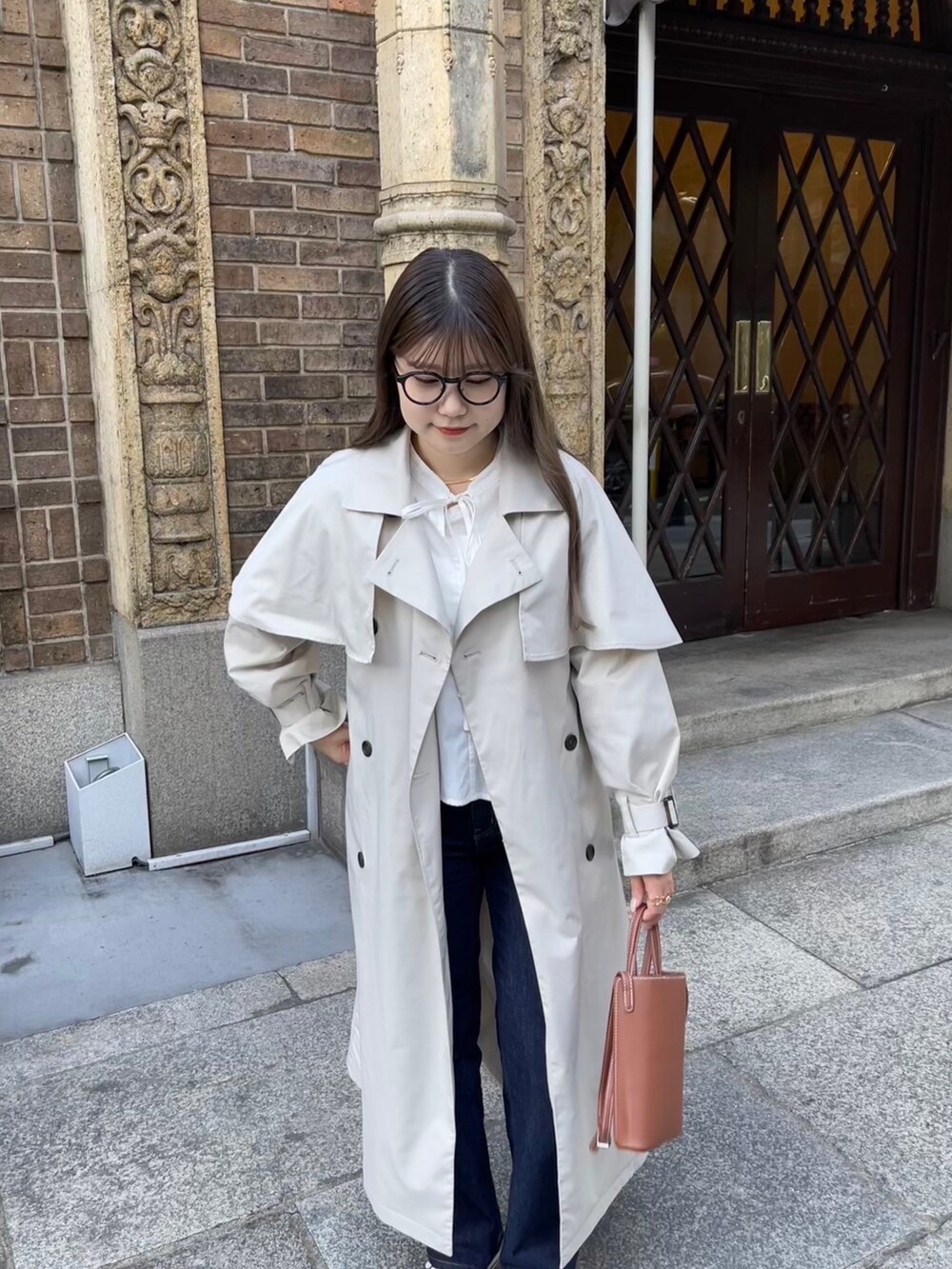 ホワイト系のシャツ/ブラウス、ベージュ系のトレンチコートを着用したレディースの冬コーディネートの3枚目の写真