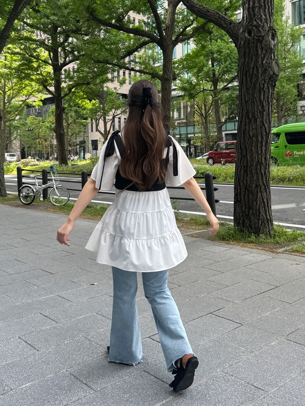 ホワイト系のシャツ/ブラウス、ブラック系のショルダーバッグ、ブルー系のデニムパンツを着用したレディースの春コーディネートの3枚目の写真