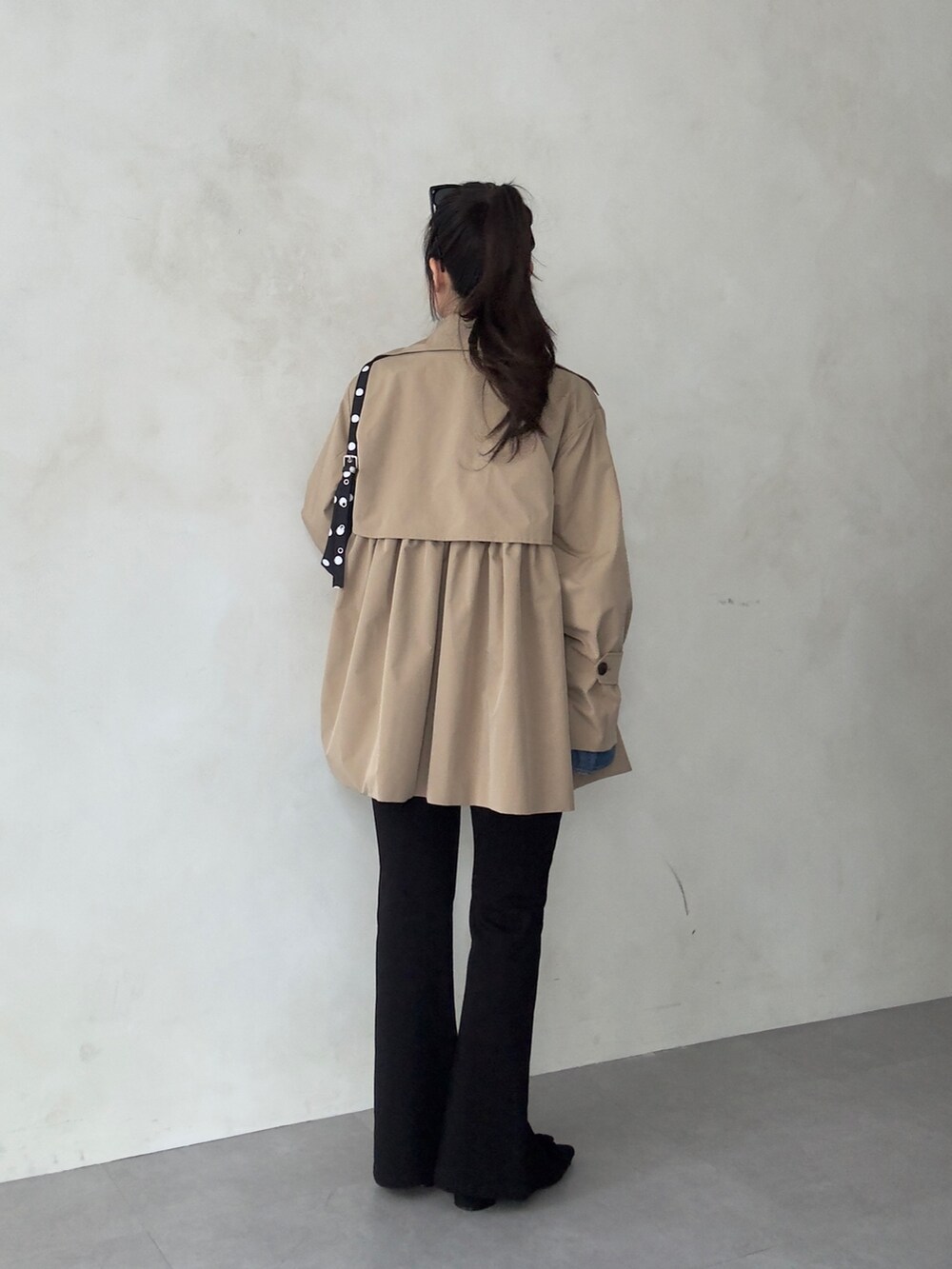 ベージュ系のトレンチコート、ブルー系のシャツ/ブラウス、ブラック系のその他パンツを着用したレディースの春コーディネートの3枚目の写真