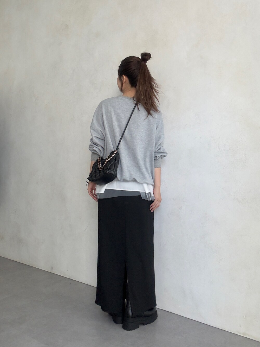 ブラック系のスカート、ブラック系のブーツ、ホワイト系のキャミソールを着用したレディースの夏コーディネートの4枚目の写真