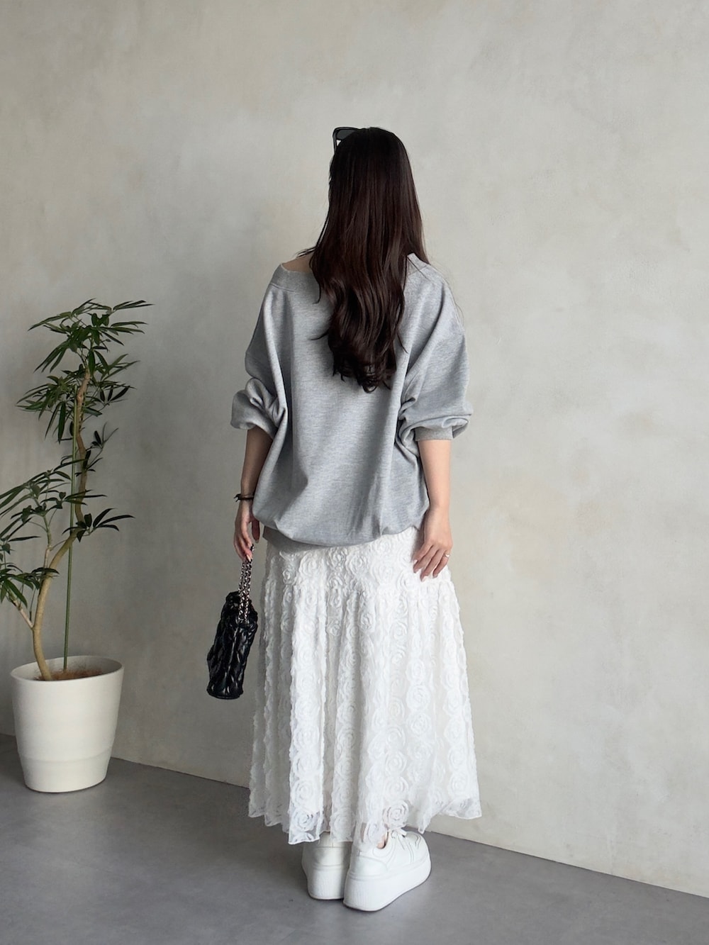 ホワイト系のスカート、ホワイト系のスニーカー、グレー系のTシャツ/カットソーを着用したレディースの春コーディネートの3枚目の写真