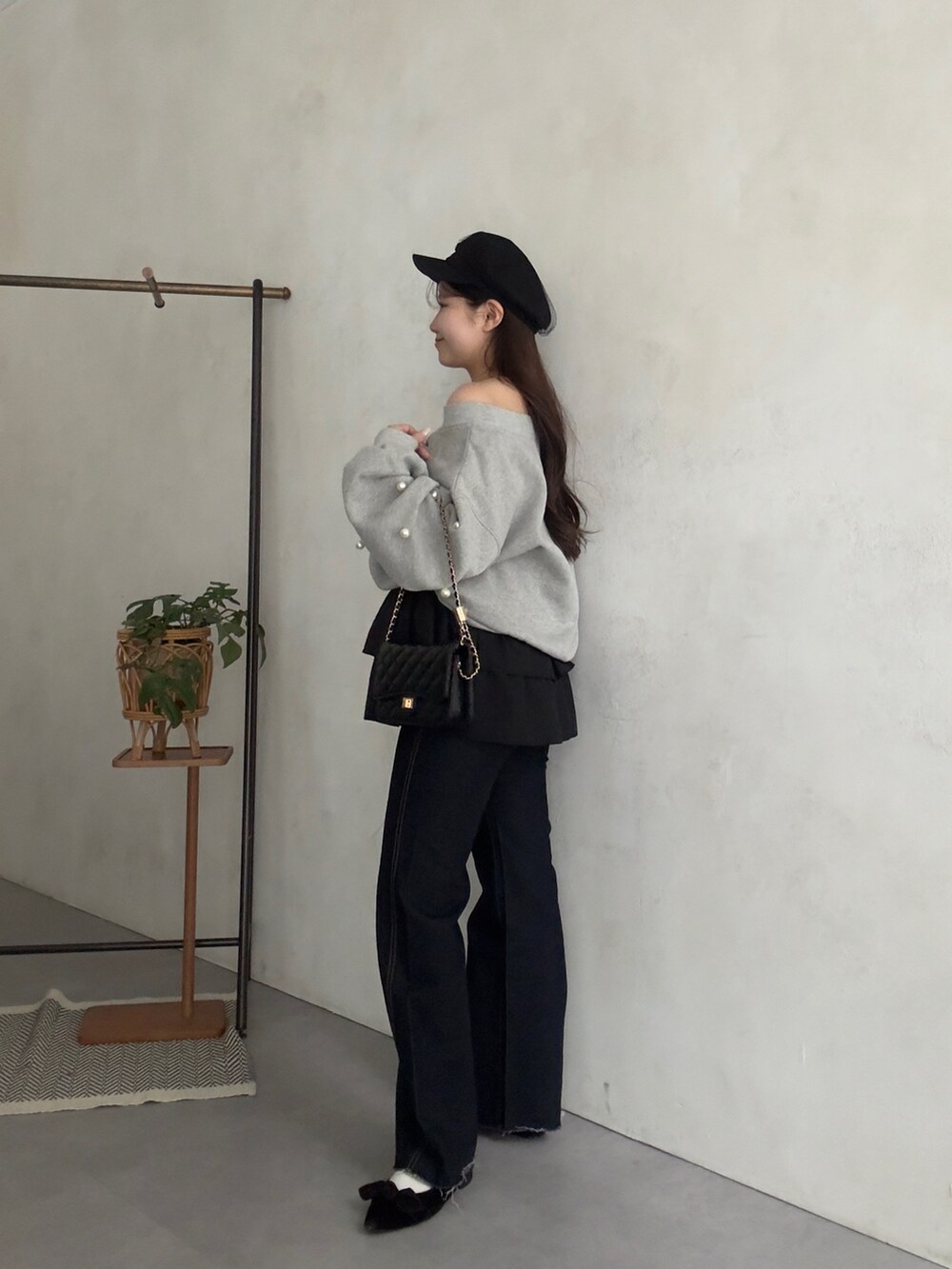 グレー系のTシャツ/カットソー、ブラック系のスカート、ブルー系のデニムパンツを着用したレディースの秋コーディネートの2枚目の写真