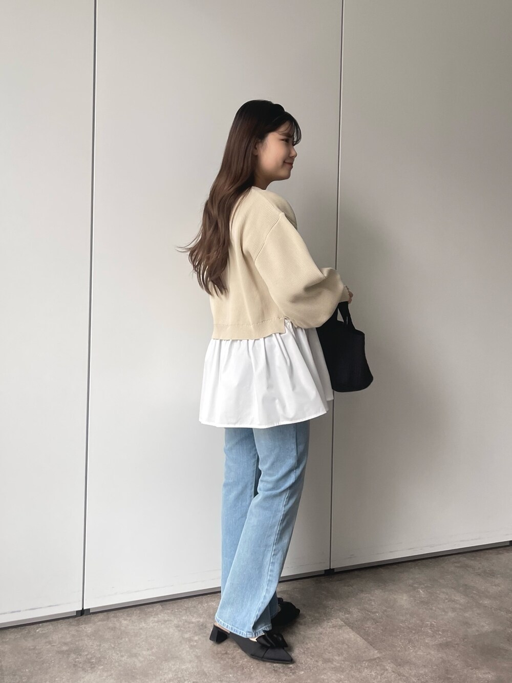 ホワイト系のカーディガン/ボレロ、ブルー系のデニムパンツ、ブラック系のトートバッグを着用したレディースの春コーディネートの3枚目の写真