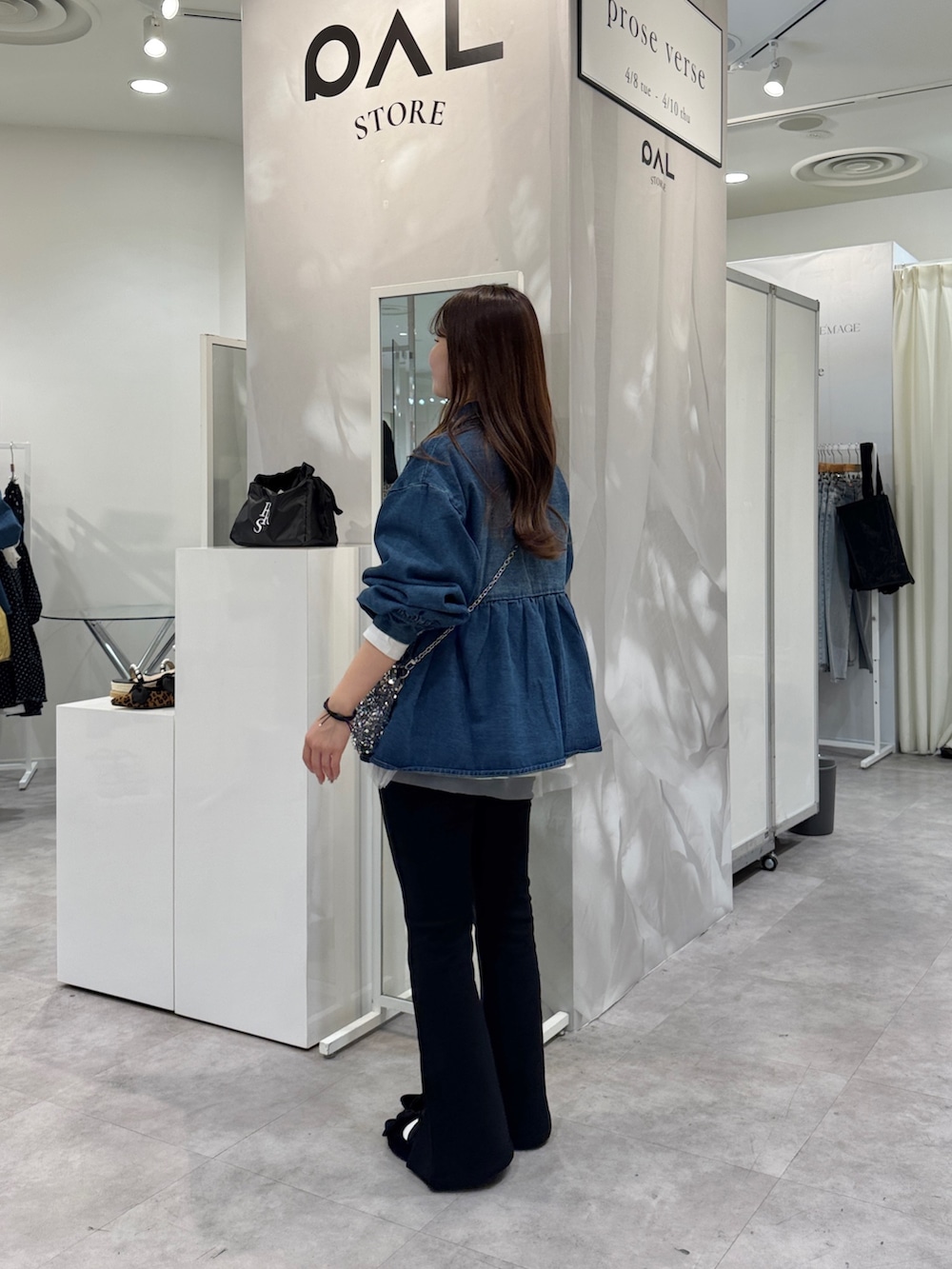 ブルー系のデニムジャケット、シルバー系のショルダーバッグ、ホワイト系のTシャツ/カットソーを着用したレディースの春コーディネートの2枚目の写真