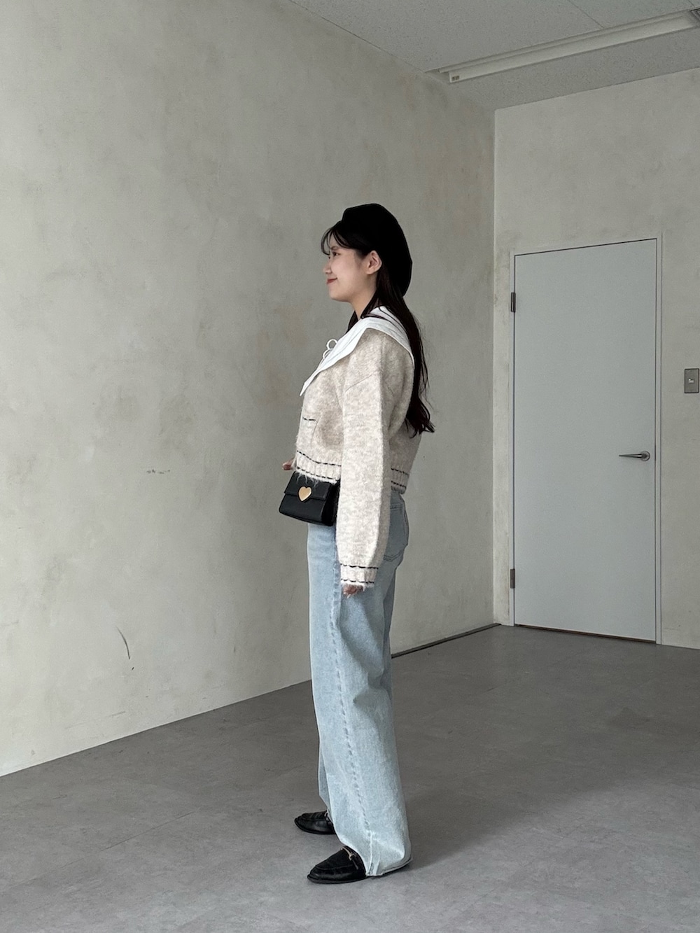 ブルー系のデニムパンツ、ホワイト系のシャツ/ブラウス、ベージュ系のカーディガン/ボレロを着用したレディースの秋コーディネートの2枚目の写真