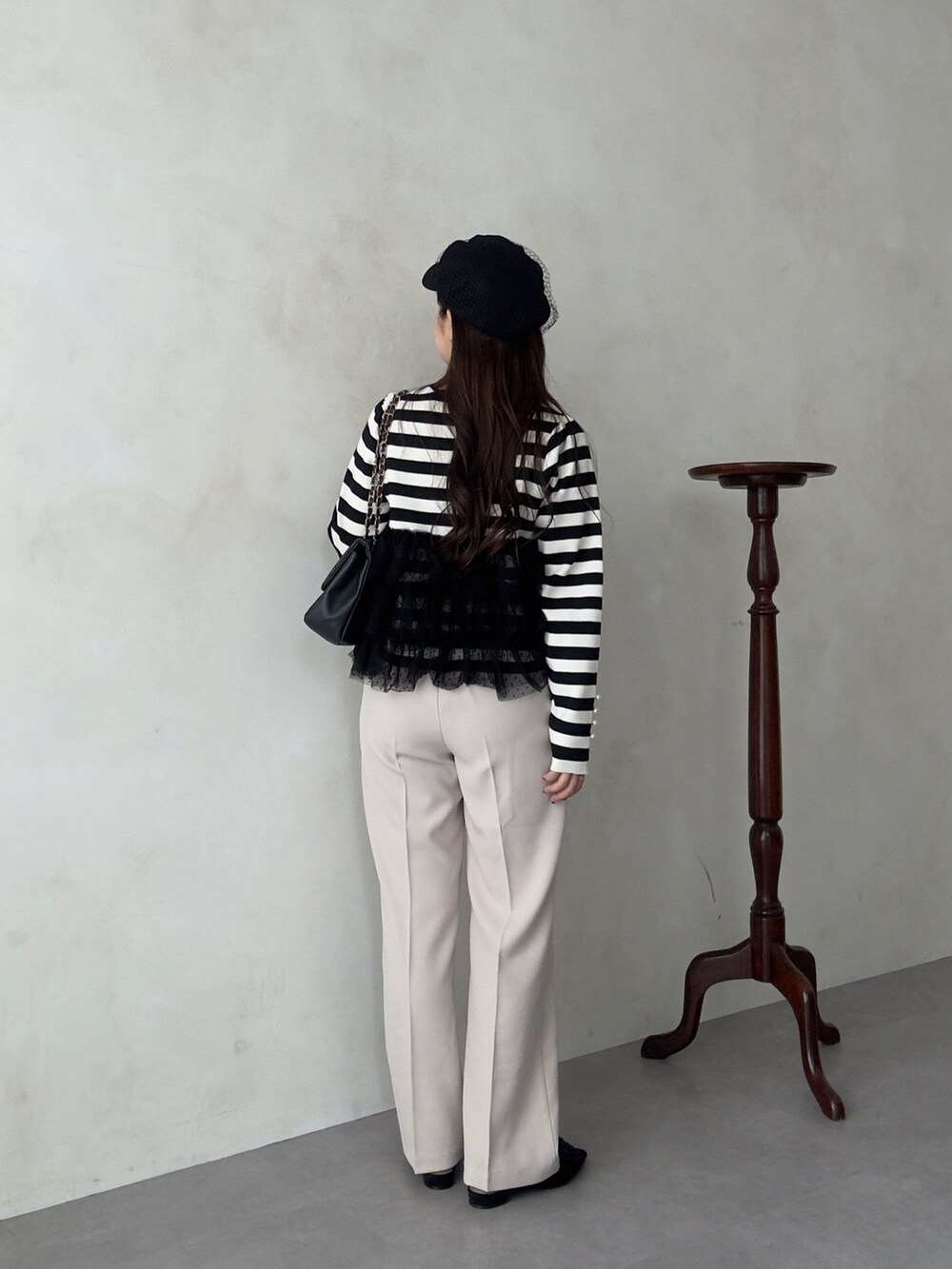 ブラック系のショルダーバッグ、ホワイト系のその他パンツ、ブラック系のニット/セーターを着用したレディースの秋コーディネートの3枚目の写真