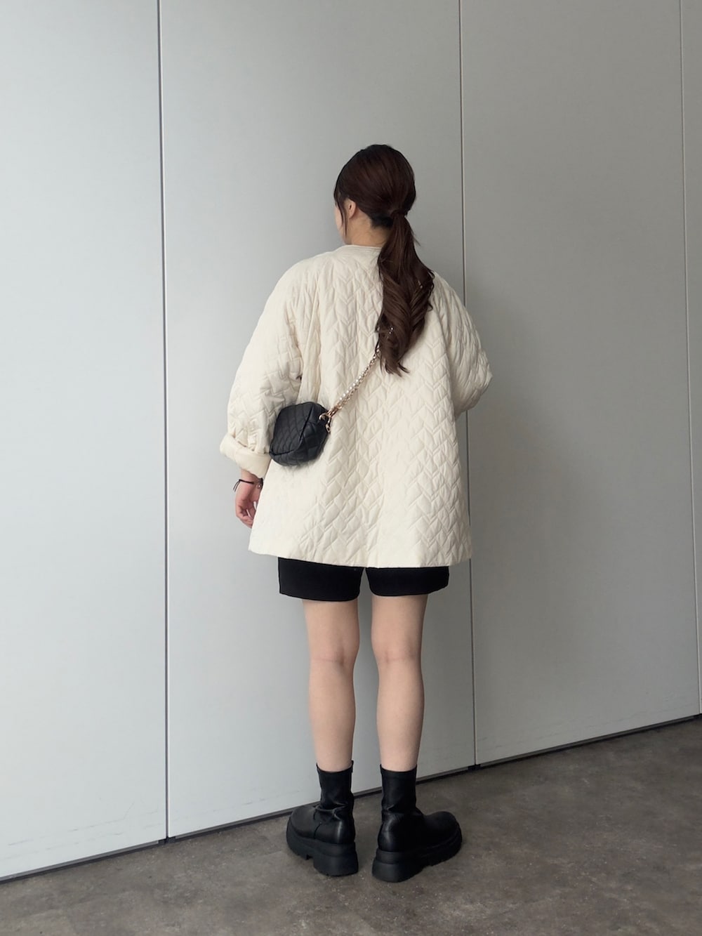 ホワイト系のブルゾン、ホワイト系のスウェット、ブラック系のショルダーバッグを着用したレディースの秋コーディネートの3枚目の写真