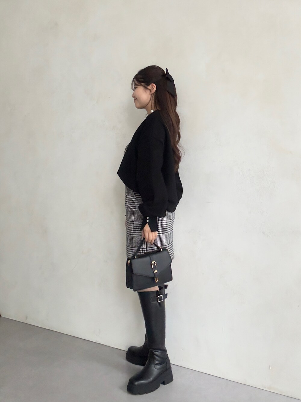 ブラック系のTシャツ/カットソー、グレー系のスカート、ブラック系のブーツを着用したレディースの秋コーディネートの2枚目の写真