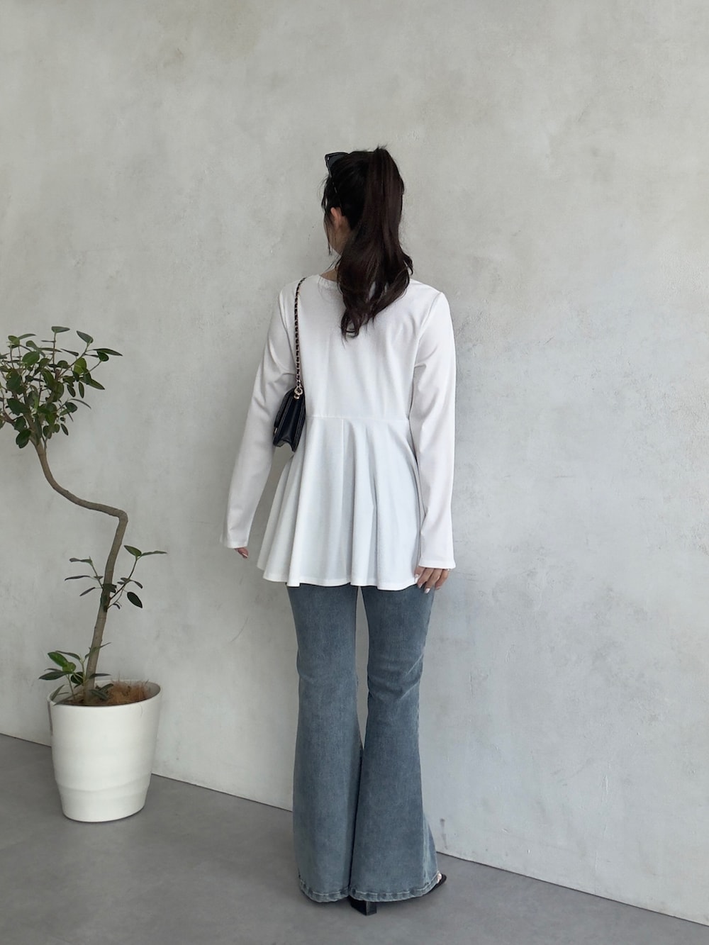 ブラック系のトートバッグ、ブルー系のデニムパンツ、ブラック系のサンダルを着用したレディースの春コーディネートの3枚目の写真