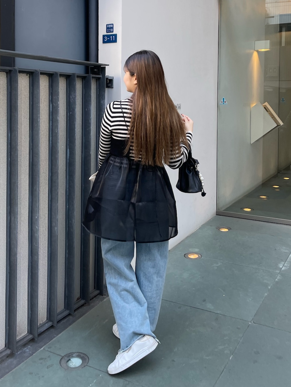 ホワイト系のニット/セーター、ブラック系のショルダーバッグ、ブラック系のキャミソールを着用したレディースの冬コーディネートの3枚目の写真