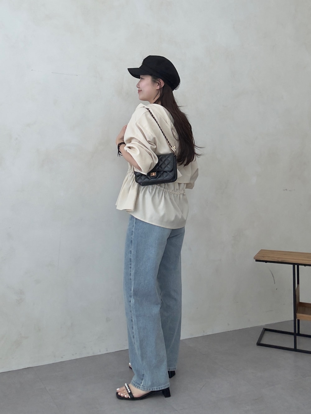 ブラック系のトートバッグ、ブラック系のサンダル、ホワイト系のブルゾンを着用したレディースの春コーディネートの2枚目の写真