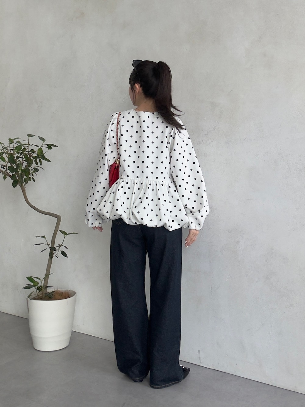 レッド系のトートバッグ、ホワイト系のシャツ/ブラウスを着用したレディースの春コーディネートの3枚目の写真