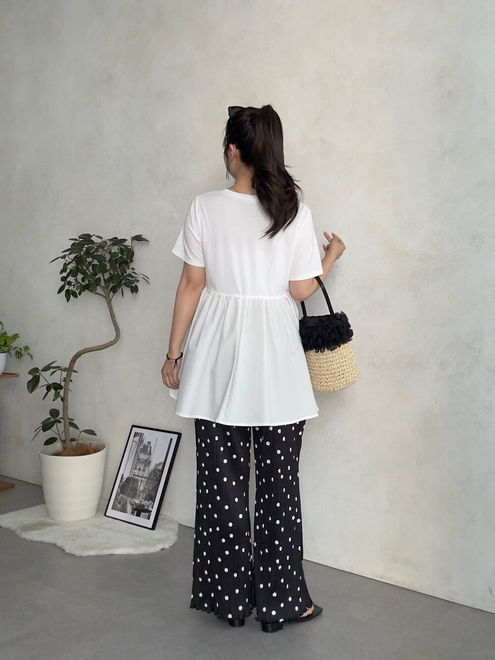 ベージュ系のかごバッグ、ブラック系のサンダル、ホワイト系のTシャツ/カットソーを着用したレディースの夏コーディネートの3枚目の写真