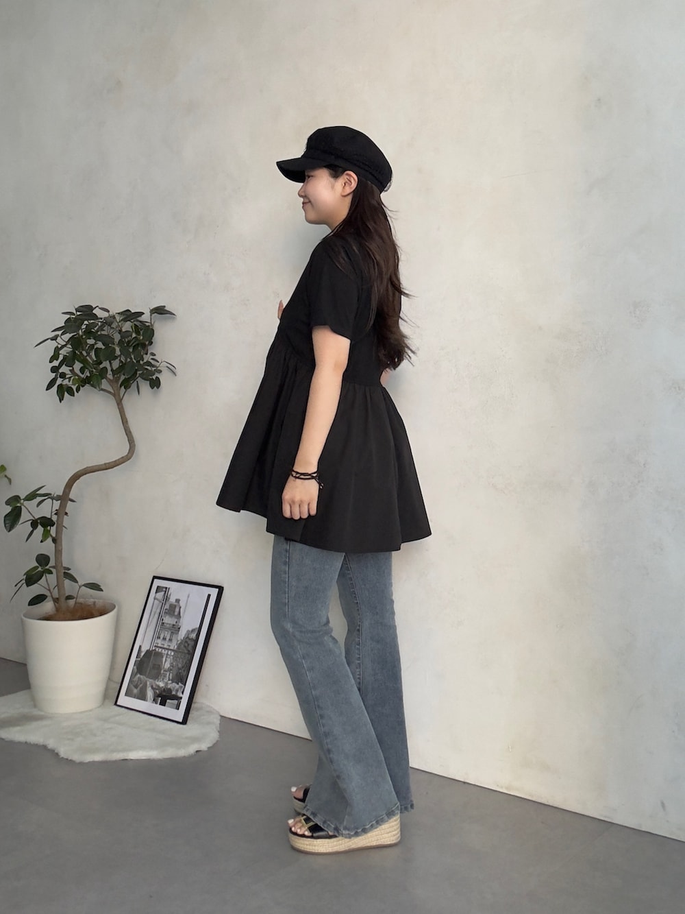 ベージュ系のかごバッグ、ブルー系のデニムパンツ、ブラック系のサンダルを着用したレディースの夏コーディネートの2枚目の写真