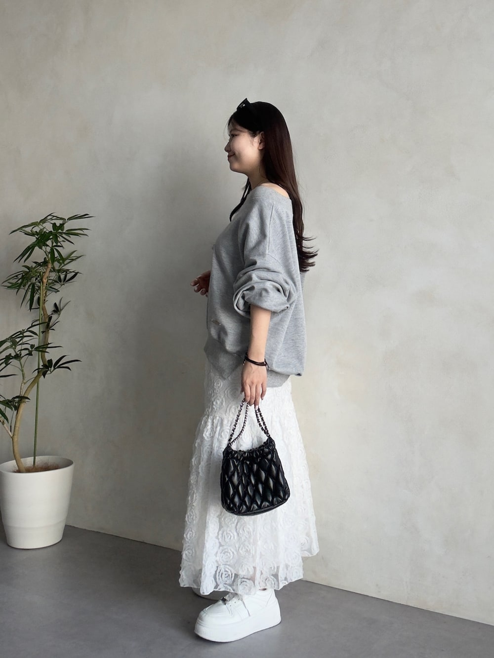 ホワイト系のスカート、ホワイト系のスニーカー、グレー系のTシャツ/カットソーを着用したレディースの春コーディネートの2枚目の写真