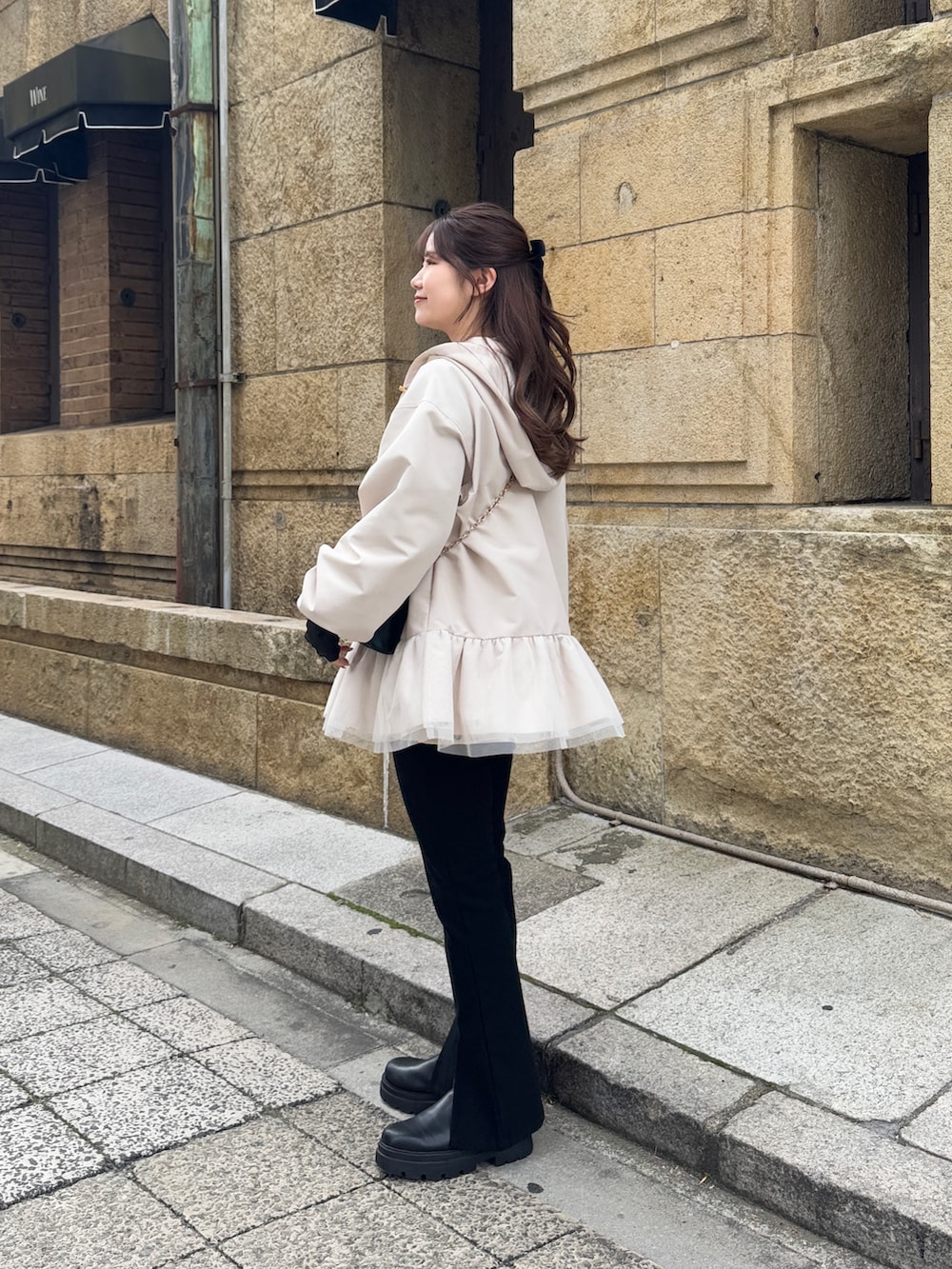 ブラック系のショルダーバッグ、ブラック系のTシャツ/カットソー、ホワイト系のキャミソールを着用したレディースの冬コーディネートの3枚目の写真