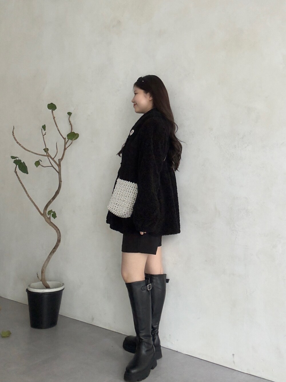 ブラック系のニット/セーター、ブラック系のその他パンツ、ブラック系のブーツを着用したレディースの秋コーディネートの2枚目の写真