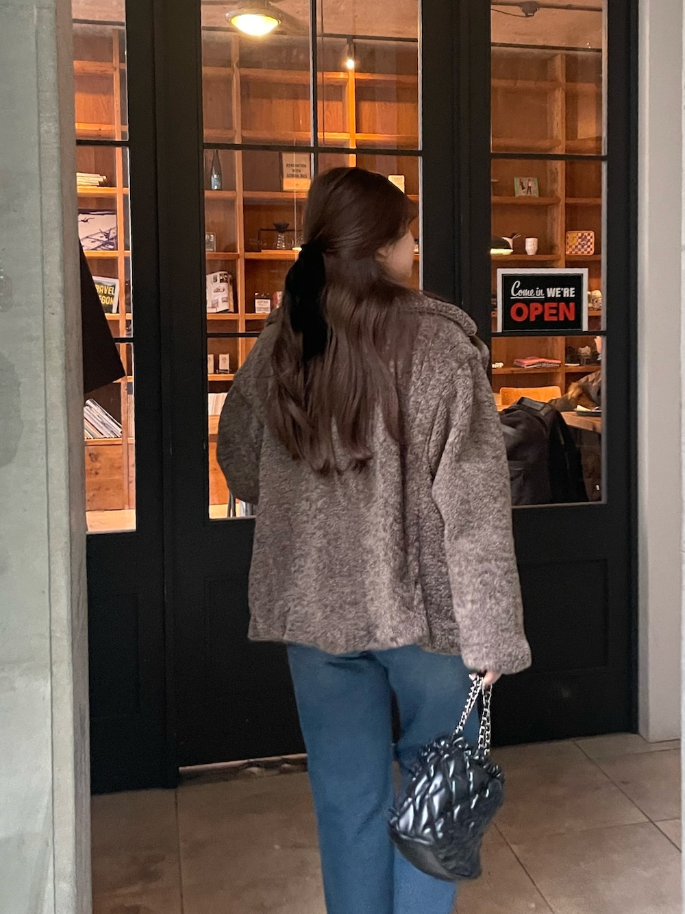 ブルー系のデニムパンツ、ブラック系のブーツ、ブラウン系のその他アウターを着用したレディースの冬コーディネートの2枚目の写真