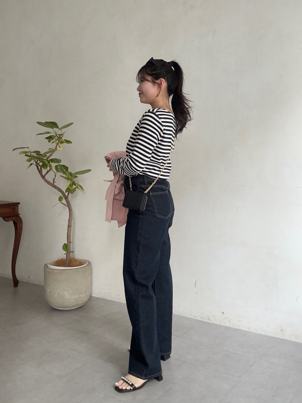 ブラック系のサンダル、ホワイト系のTシャツ/カットソーを着用したレディースの春コーディネートの2枚目の写真