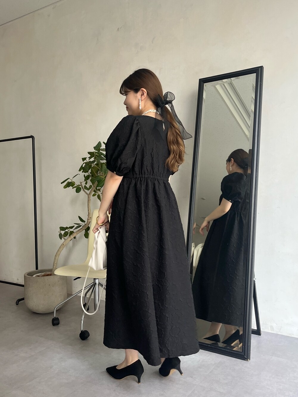 ブラック系のドレス、ホワイト系のネックレス、ブラック系のヘアゴムを着用したレディースの春コーディネートの3枚目の写真