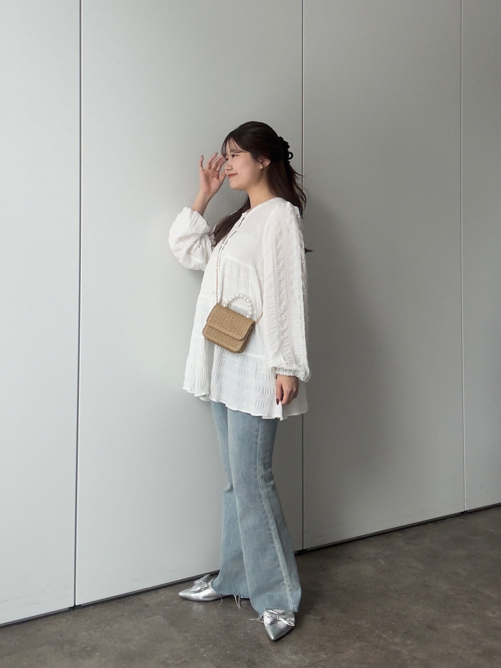 ホワイト系のシャツ/ブラウス、ブルー系のデニムパンツ、シルバー系のパンプスを着用したレディースの春コーディネートの2枚目の写真