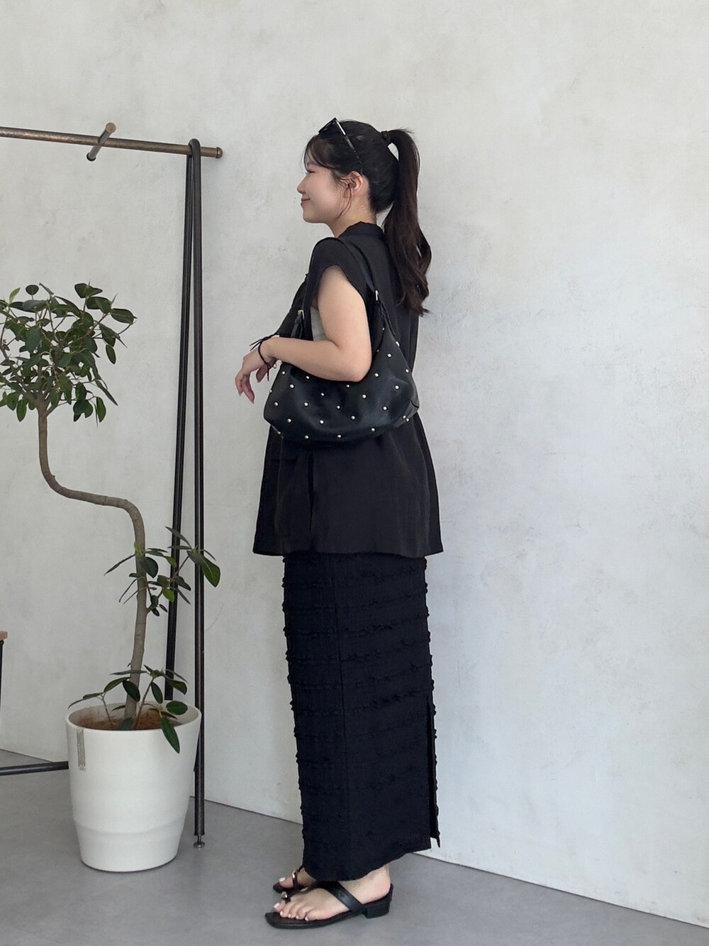 ブラック系のショルダーバッグ、ブラック系のサンダル、ブラック系のベストを着用したレディースの夏コーディネートの2枚目の写真