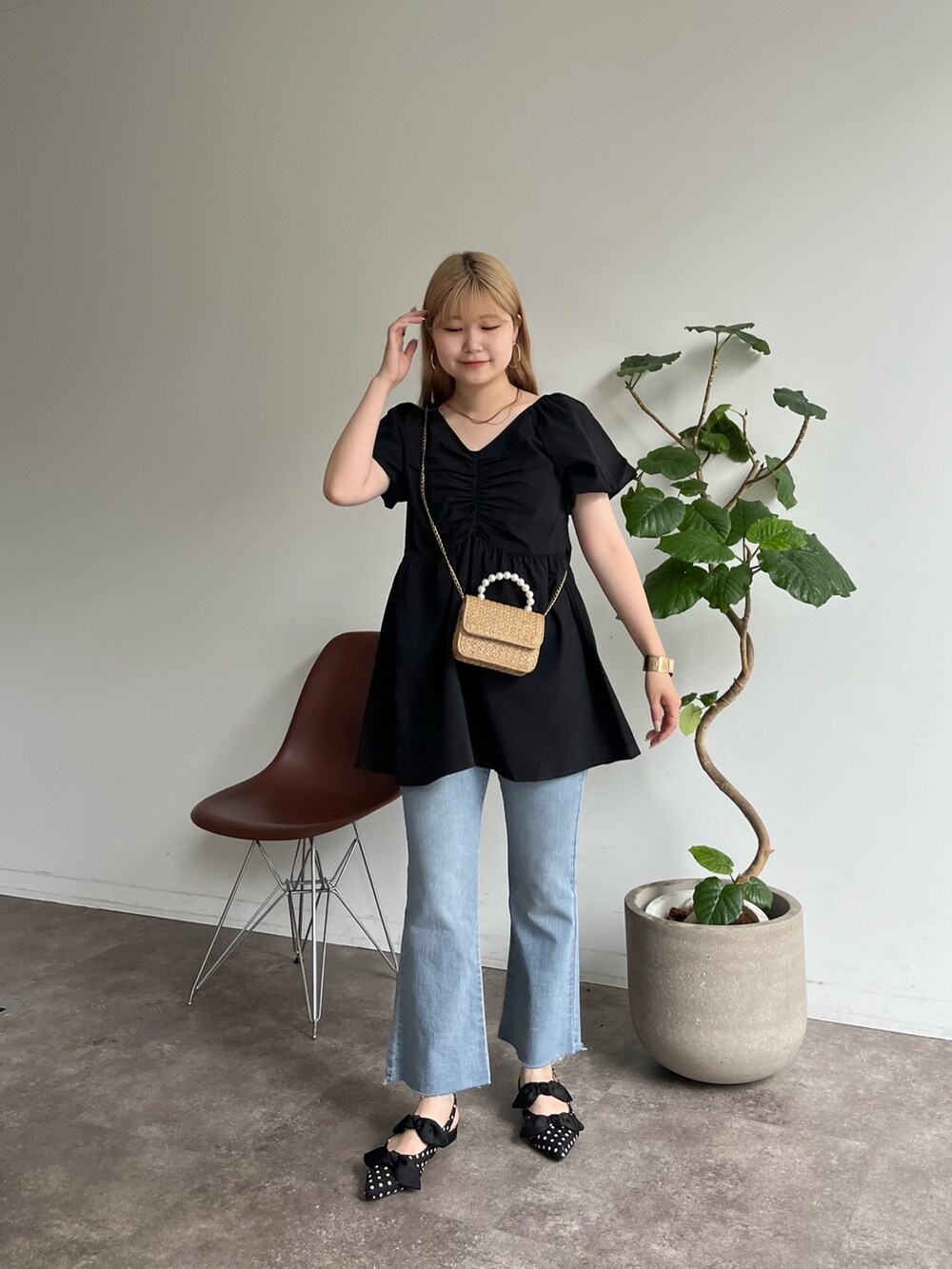ベージュ系のショルダーバッグ、ブルー系のデニムパンツ、ブラック系のパンプスを着用したレディースの夏コーディネートの2枚目の写真