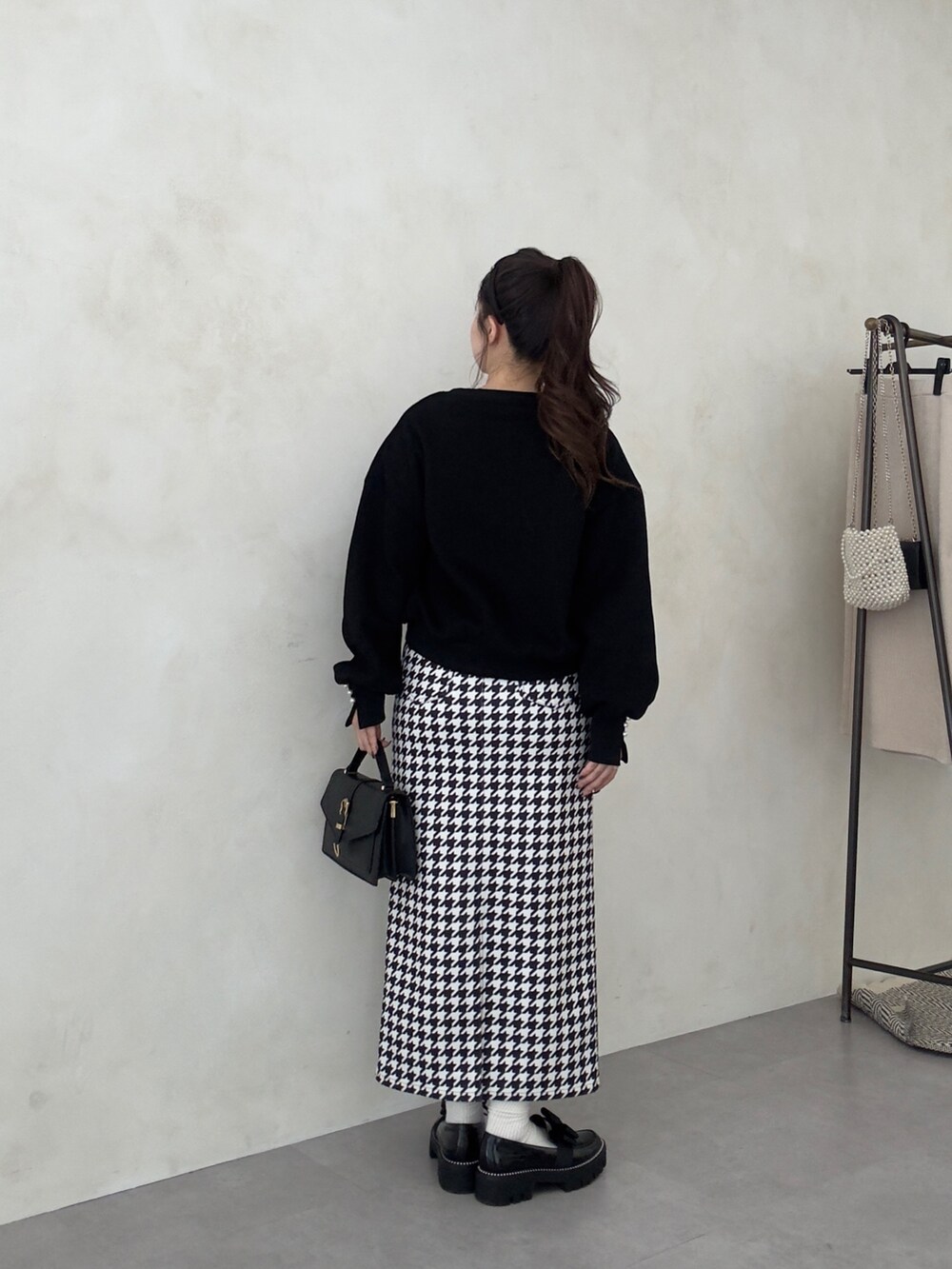 ブラック系のローファー、ブラック系のTシャツ/カットソー、ブラック系のスカートを着用したレディースの秋コーディネートの3枚目の写真