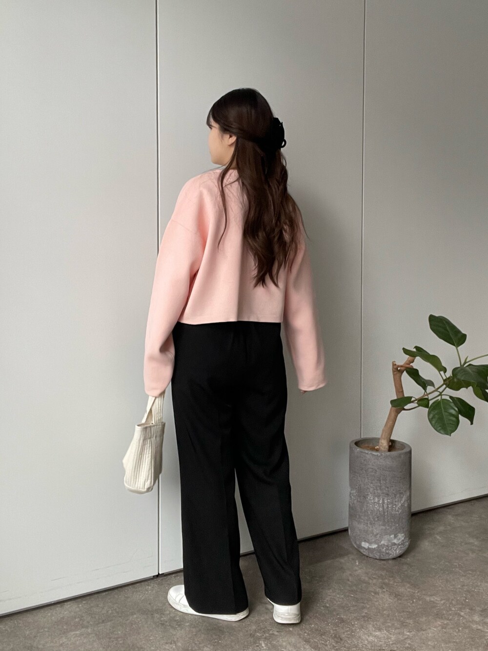 ピンク系のカーディガン/ボレロ、ホワイト系のTシャツ/カットソー、ブラック系のスラックスを着用したレディースの冬コーディネートの3枚目の写真