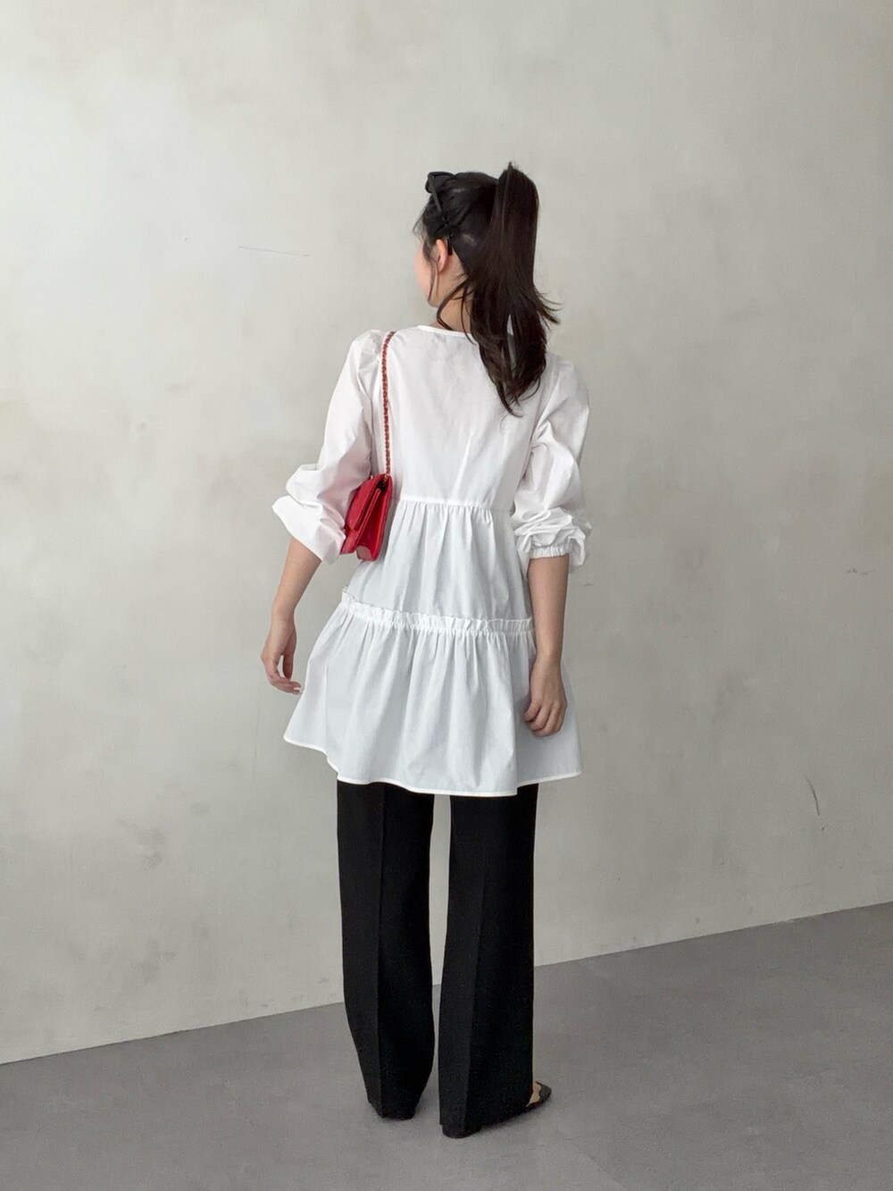 レッド系のトートバッグ、ホワイト系のシャツ/ブラウス、ブラック系のその他パンツを着用したレディースの春コーディネートの3枚目の写真