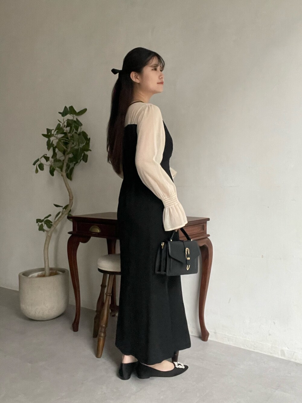 ブラック系のドレス、ブラック系のパンプス、ブラック系のその他ヘアアクセサリーを着用したレディースの春コーディネートの2枚目の写真