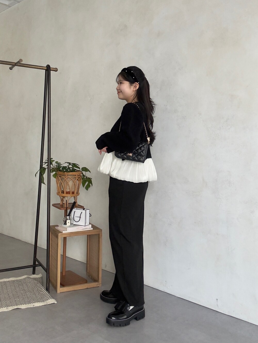 ブラック系のカーディガン/ボレロ、ブラック系のスカート、ブラック系のローファーを着用したレディースの冬コーディネートの2枚目の写真