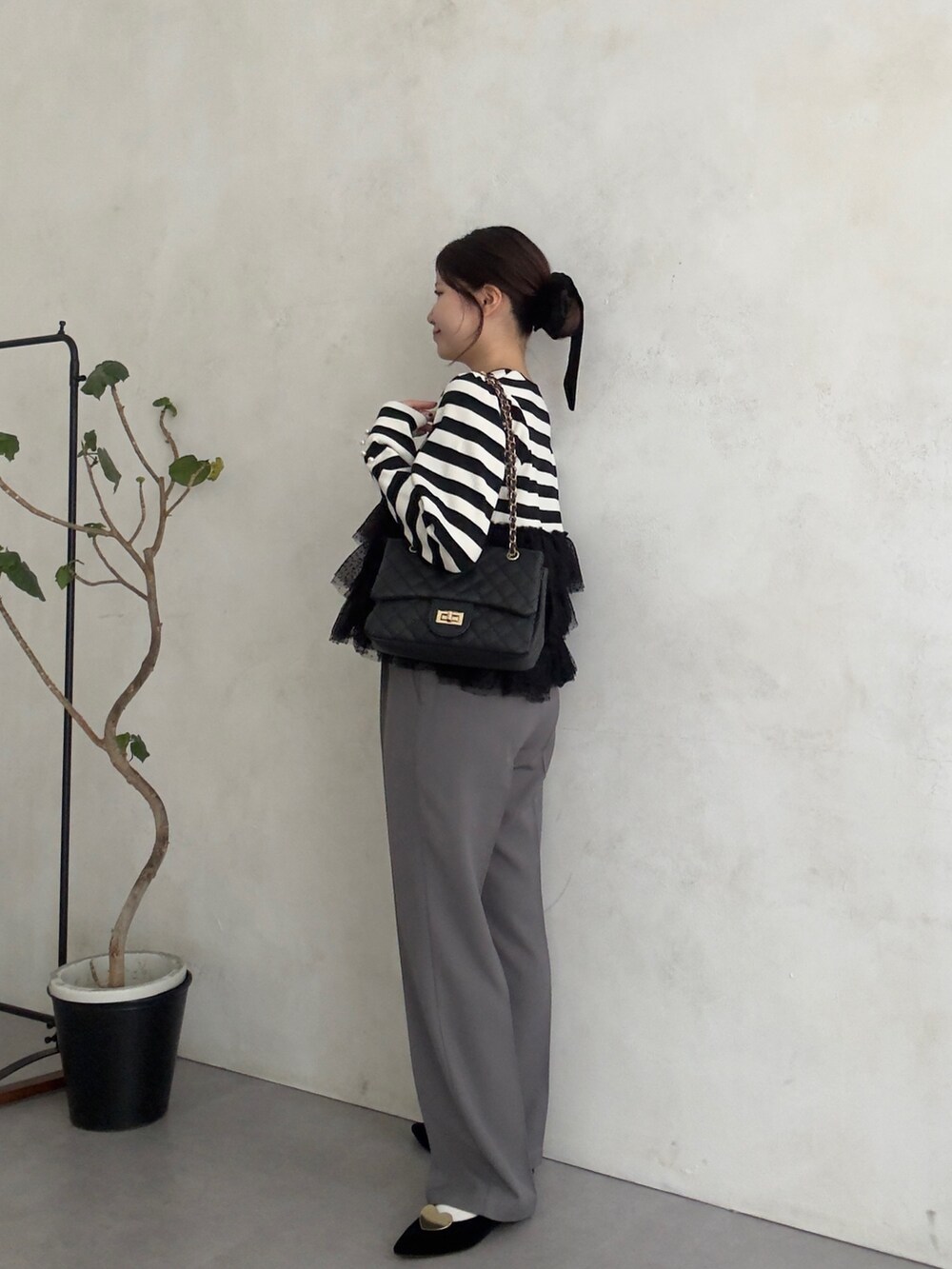 ブラック系のニット/セーター、グレー系のその他パンツを着用したレディースの秋コーディネートの2枚目の写真